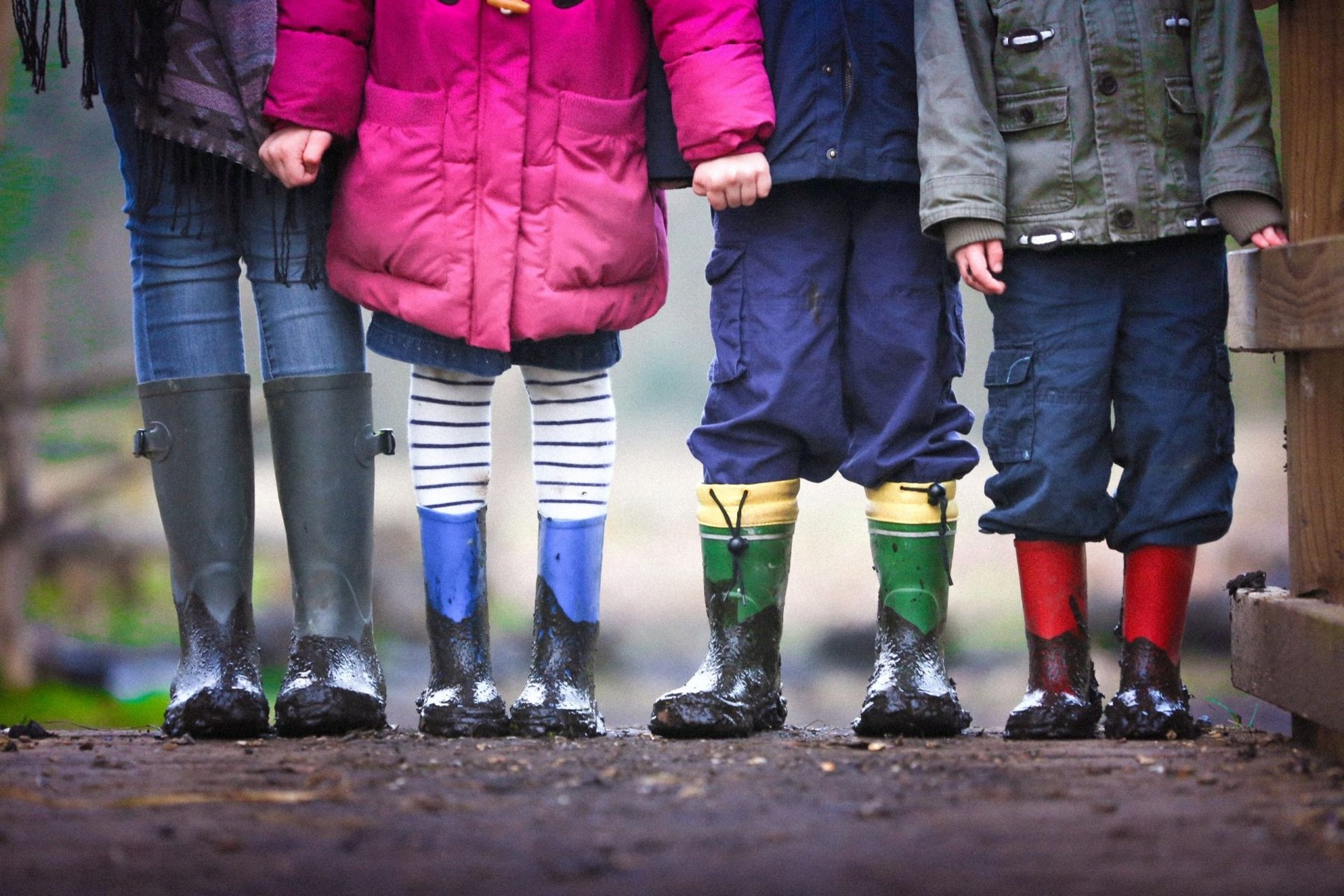 Children standing together in colorful rain boots